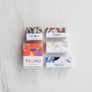 Image of 5 Tsuno products on a marble background.  Bamboo panty liners, bamboo regular pads, mini, regular and super organic cotton tampons.